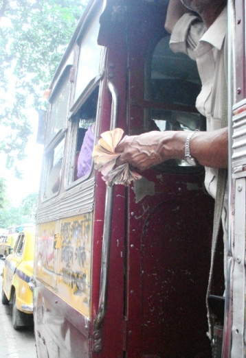 The hardworking hand of the bus conductor, deftly handling the wad of cash...all in a day's work!